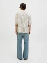 Camisa de manga corta con estampado de cachemira en tonos beige y blanco, cuello resort y cierre de botones. Confeccionada en tejido plano con mezcla de algodón y lino, de corte amplio.