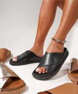 Sandalias negras con tiras cruzadas de cuero sintético y suela plana.