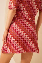 Minifalda de tejido de punto con estampado geométrico en tonos rojo, rosa, naranja y blanco.