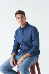 Camisa marrón de manga larga con bolsillo en el pecho y cierre con botones.