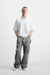 Polo blanco de piqué con corte relaxed fit, cuello solapa y cierre frontal con botones.