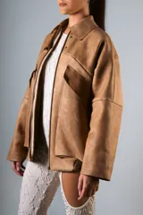 Campera estilo bomber confeccionada en cuero vacuno color marrón claro, de estructura firme y calce holgado.
