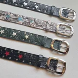 Cinturón de cuero con hebilla metálica plateada y apliques de estrellas.