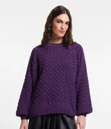 Suéter color violeta en tejido de punto con textura de punto onda, cuello redondo y mangas largas abullonadas.