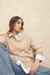 Cardigan corto tramado de color gris, de manga larga y cuello redondo con botones grandes, elastizado y suave.