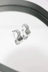 Par de aros tipo argolla plateados, con triple aro y cierre a presión.