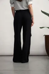 Pantalón cargo color verde oliva, de corte ancho, con bolsillos laterales con solapa y cintura con cordón ajustable.