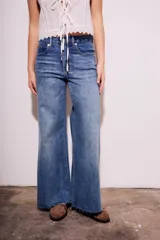 Pantalón de jean de tiro medio, color celeste, corte flared y wide leg.