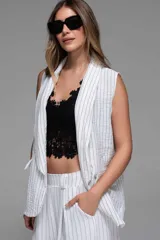 Chaleco azul marino con finas rayas verticales blancas, sin mangas, con solapas y bolsillos frontales.