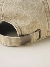 Gorra de gabardina color gris oscuro con visera curva y etiqueta con logo de la marca en el lateral.