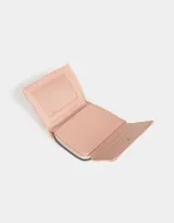 Billetera de cuerina color rosa con estampado escocés, solapa con broche y tag metálico.