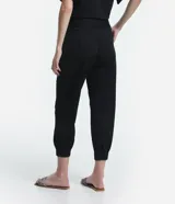 Pantalón jogger color naranja, de tiro medio, con cintura elástica, lazo ajustable y pliegues delanteros.