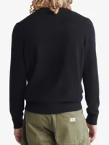 Sweater negro de lana merino de cuello redondo y corte clásico. Tiene puños y dobladillo con punto canalé.