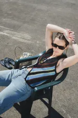 Chaleco calado negro con diseño de rayas diagonales rojas, beige y blancas.