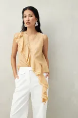 Top blanco de tencel sin mangas, de corte asimétrico, con volados en diagonal.