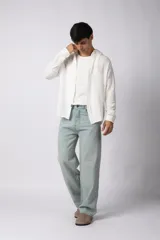 Camisa de lino blanca de manga larga, con cuello clásico y cierre frontal con botones. Corte recto y holgado.