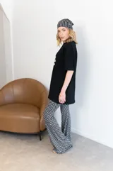 Pantalón palazzo negro con lunares blancos, confeccionado en viscosa.