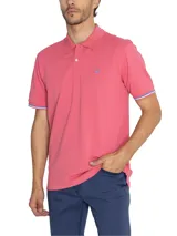 Chomba color salmón de piqué de algodón pima, con cuello clásico, tapeta de dos botones y logo bordado en el pecho.