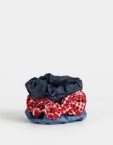 Set de tres scrunchies para el pelo, uno de denim azul oscuro, uno de denim azul claro y uno de tela a cuadros rojos y blancos con volados.