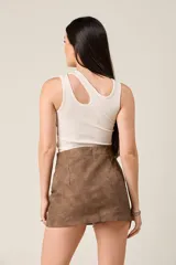 Minifalda negra de corte ajustado, con cierre metálico frontal y dos bolsillos con cierre en la parte delantera.