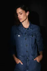 Mono largo de denim azul, con bolsillos delanteros y traseros, badana de PU en la espalda y avíos metálicos.
