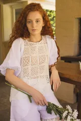 Blusa blanca con cuerpo de encaje de crochet cuadrillé y mangas abuchonadas de lino.