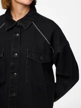 Camisa de denim negra con mangas largas, calce regular, bolsillos frontales y detalles de cristales en los hombros.