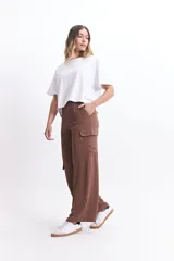 Pantalón cargo marrón de corte ancho, con bolsillos laterales tipo cargo y textura de lino.