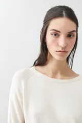 Sweater básico de tejido de punto color beige, de corte recto y mangas largas.