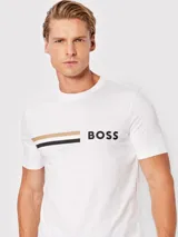 Remera blanca de algodón de corte regular fit, con dos franjas horizontales en color beige y negro y logo de la marca Boss en negro.