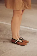 Bailarinas de cuero negro con puntera redondeada y tira sobre el empeine con apliques de esferas metálicas.