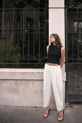 Camiseta sin mangas a rayas horizontales blancas y negras, con cuello barco y corte ajustado.
