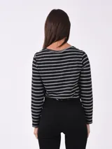 Remera marrón de manga larga con cuello redondo y detalle de botones dorados en los hombros.