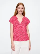Blusa blanca de manga corta con escote en V y detalle de volados en el cuello.