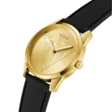 Reloj Guess con caja dorada y esfera dorada con relieve de triángulo texturizado. Posee agujas blancas y correa de silicona negra.