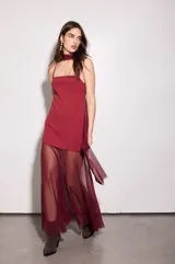 Vestido bordó con base de crepé asimétrico y capa de gasa. Incluye capa a juego que puede usarse como chal o corbatín.