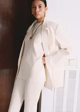 Top color crema de tejido de punto fino en canalé, con cuello redondo, diseño recto y sin mangas.