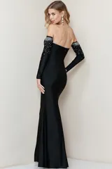 Vestido largo de fiesta negro, strapless, con mangas largas separadas y apliques de strass en el busto y en los puños.