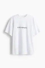 Remera deportiva blanca de corte holgado con cuello redondo ribeteado acanalado y bajo recto. Estampado frontal con la frase "In My Sculpting Era" en color negro.