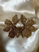 Par de aros con forma de flor roja brillante y detalle de strass plateado en el centro. Cierre a presión de acero inoxidable.