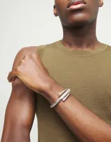 Pulsera rígida plateada con diseño de espiral abierto.