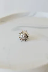 Anillo plateado con forma de sol con rostro, ajustable entre 16mm y 19mm. Fabricado en acero quirúrgico hipoalergénico.