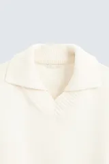Sweater color crema de punto con cuello polo y escote en V.