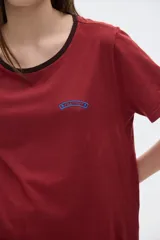 Remera color borgoña de algodón lavado, con cuello redondo ribeteado en negro, manga corta y corte oversized.