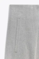 Pantalón gris de tiro alto con costuras marcadas en delantero y espalda, bolsillos delanteros de vivo y cierre frontal con cremallera, botón interior y gancho metálico.