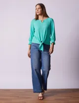 Blusa verde agua de tejido texturado marca Ruby Rd, con cuello a la base, escote en V con aplique metálico, mangas tres cuartos con puños elásticos y terminación de ruedo con nudo.