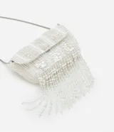 Bolso de fiesta blanco con lentejuelas y flecos de cuentas. Tiene asa de cadena plateada y cierre con botón a presión.