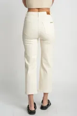 Pantalón de jean color crudo, corte recto, tiro medio, confeccionado en algodón peinado con elastano.