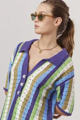 Sweater de tejido crochet a rayas verticales en tonos azul, verde, marrón y blanco, con cuello polo y cierre de botones.