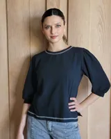 Remera negra de mangas largas con detalle de costuras en color gris en cuello y ruedo.